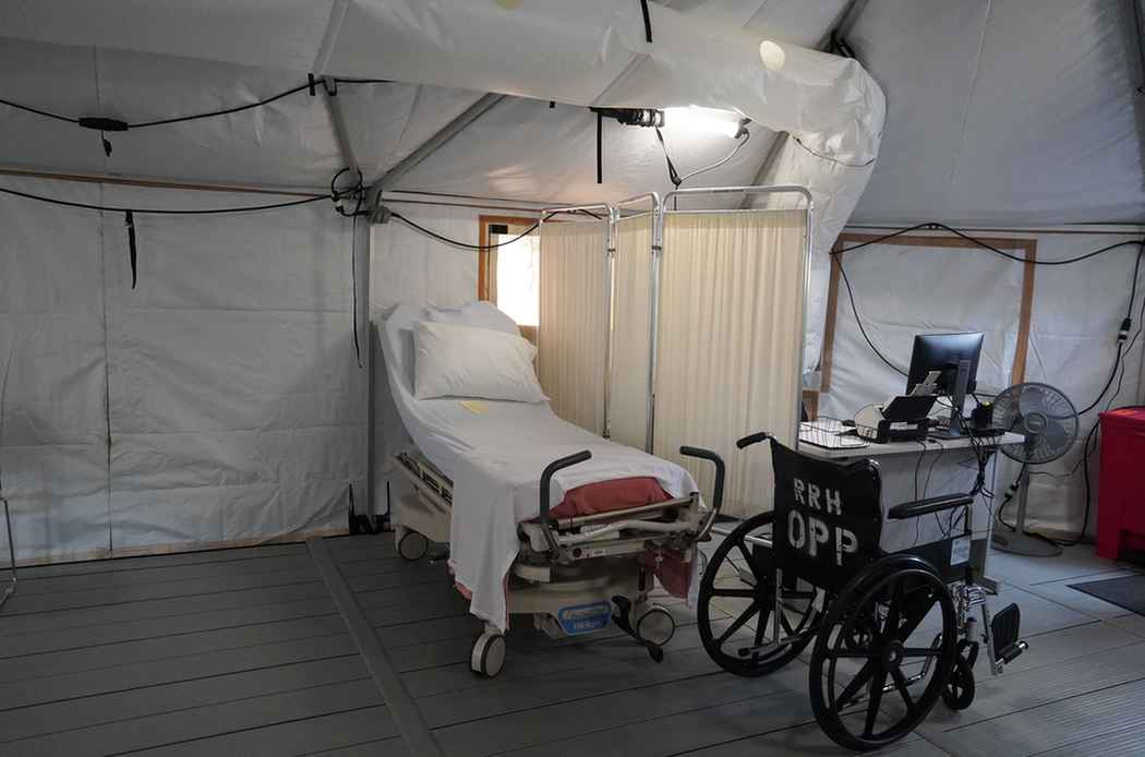 Bed and wheelchair inside the emergency department tent