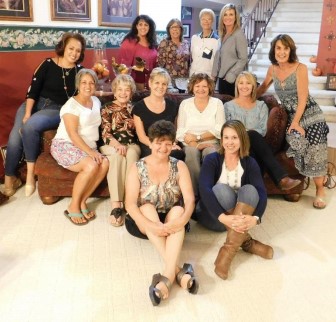 group of women sitting on and around a couch